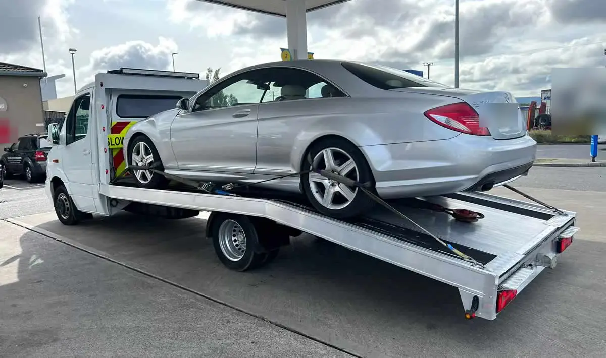 A silver coupe loaded at a fuel station forecourt