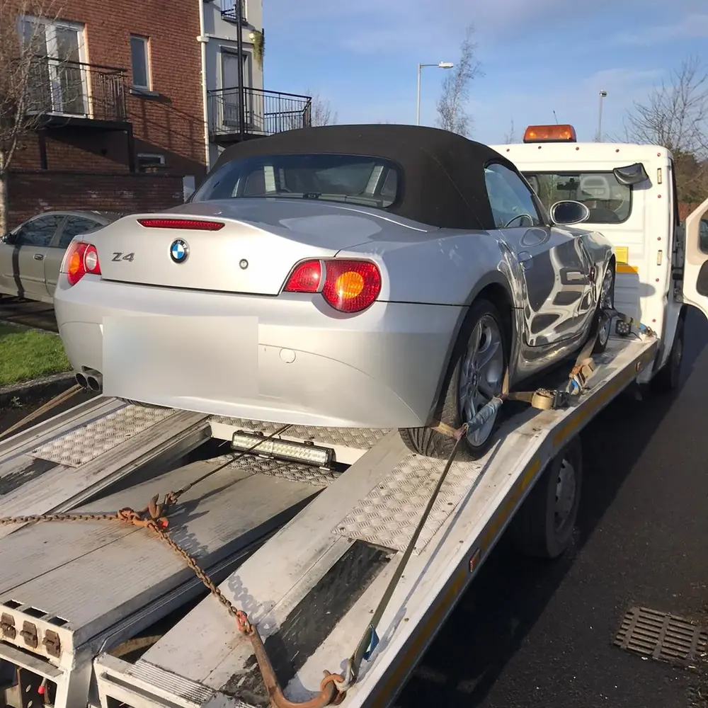 A roadster strapped onto the deck for vehicle transportation